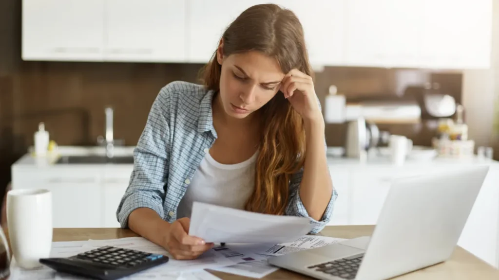 Mulher vendo como economizar dinheiro pagando dívidas.