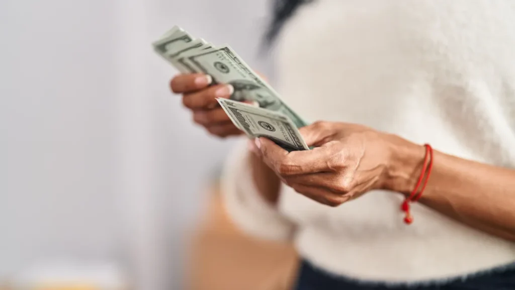 Mulher contando dinheiro para controlar o orçamento